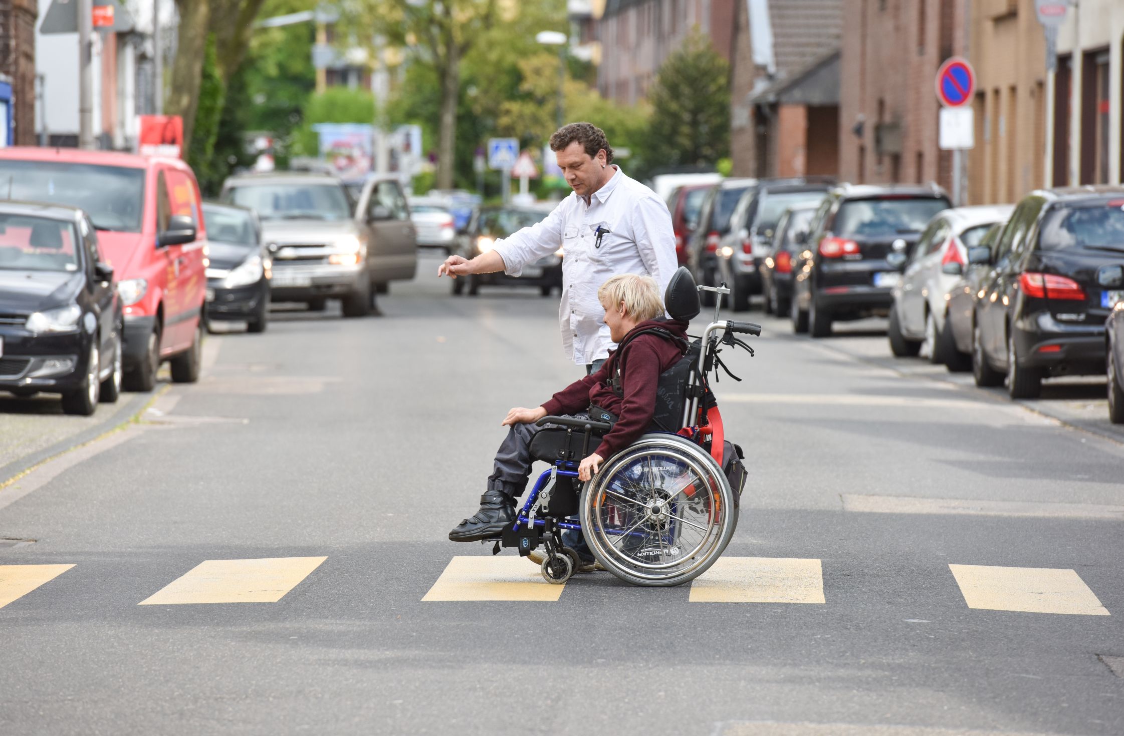 Rollstuhlfahrer auf Zebrastreifen